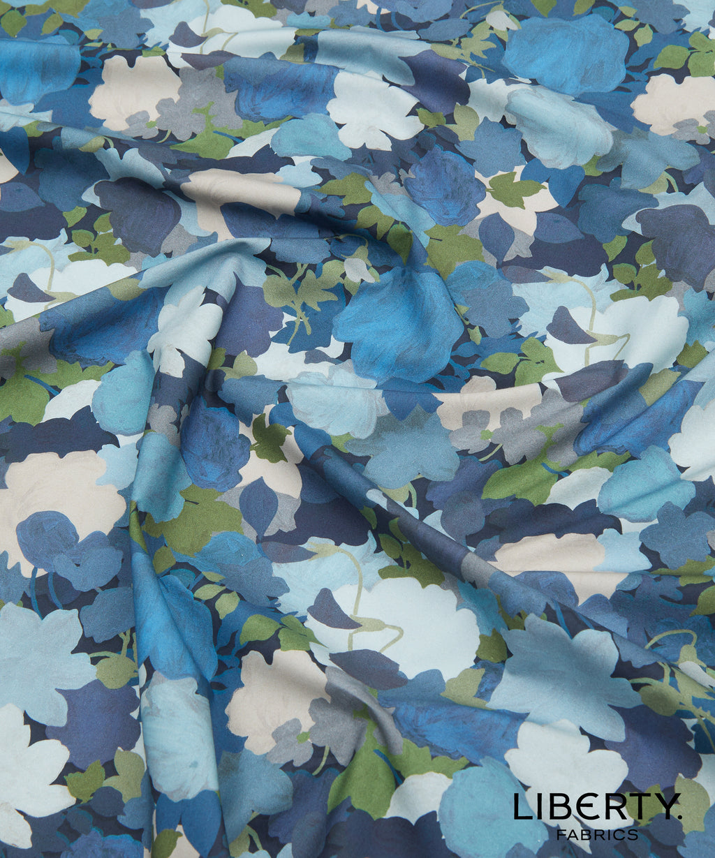 Floral fabric with blue, green, and white pattern by Liberty Fabrics made in Italy