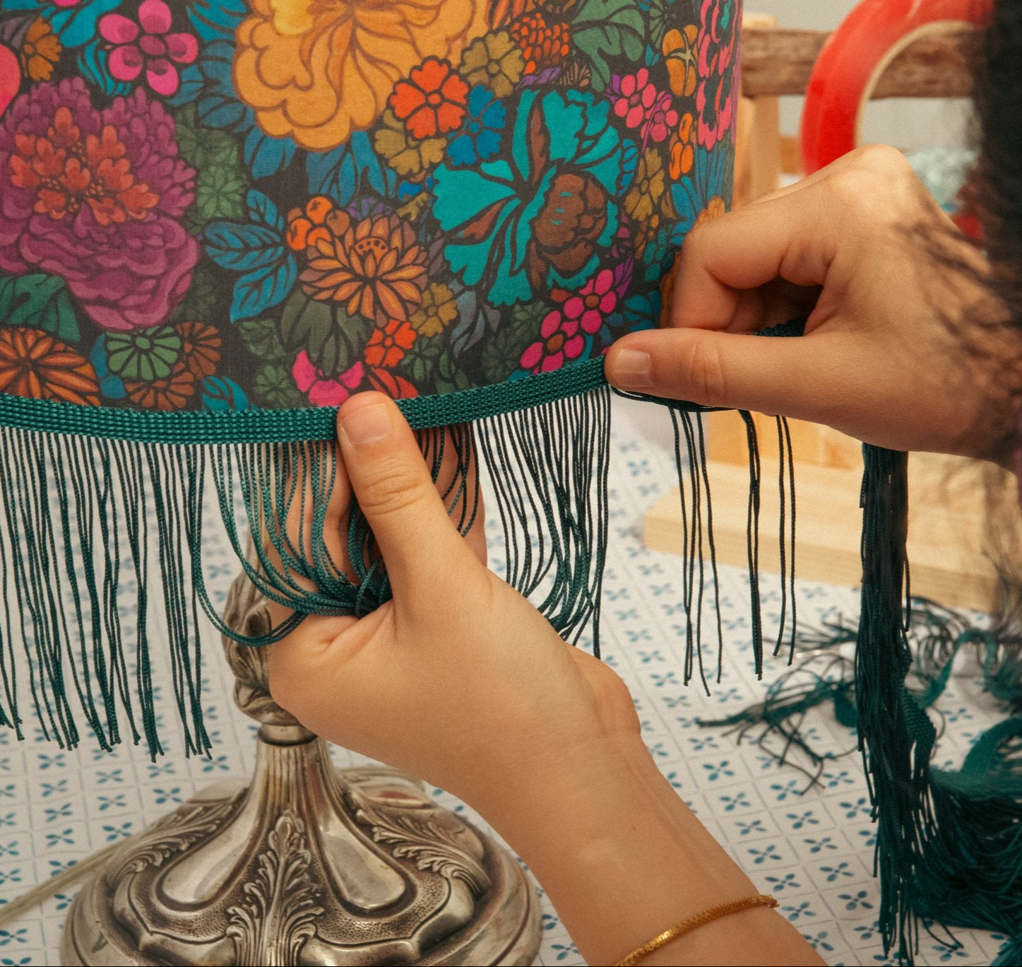 
Close-up of handmade Liberty fabric lampshade by Kikiwi, adding teal fringe trim for a colourful, retro finish