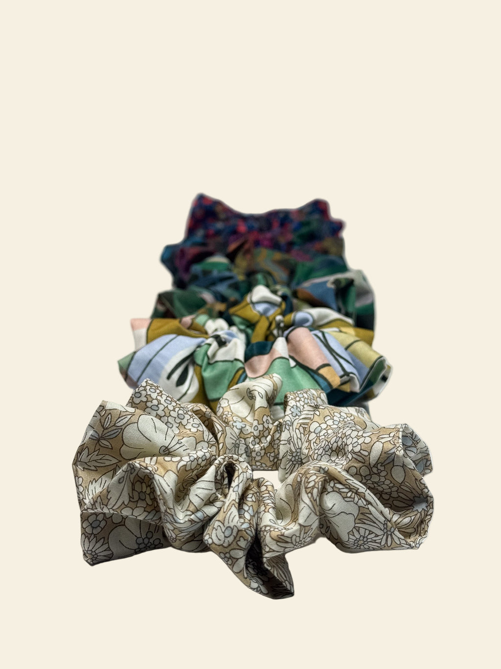 Set of colourful fabric scrunchies on a light gray background by Kikiwi