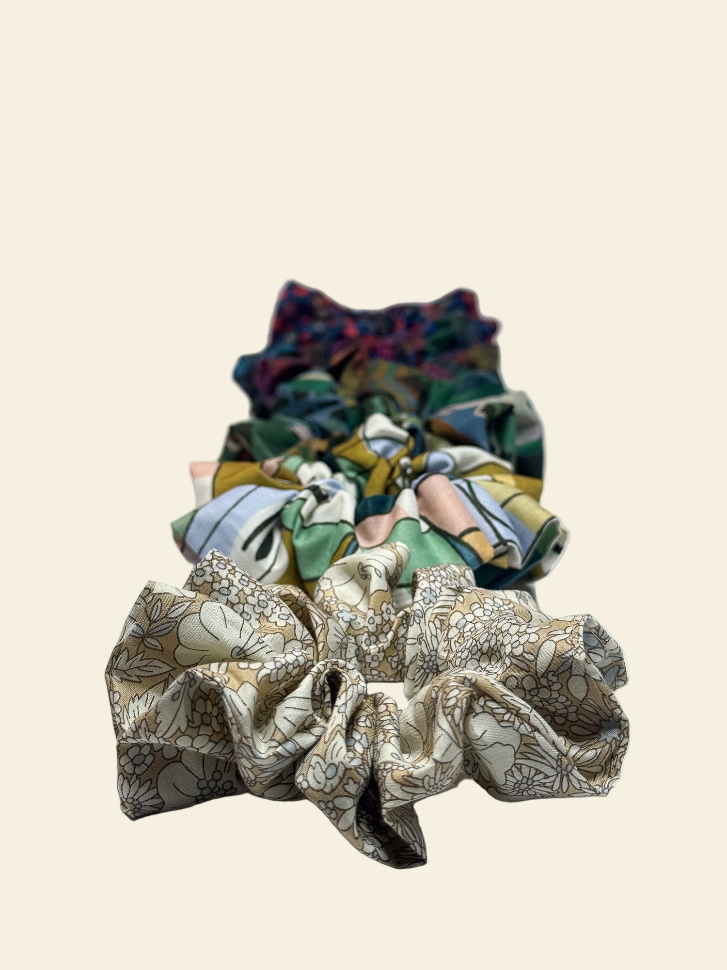 Set of colourful fabric scrunchies on a light gray background by Kikiwi
