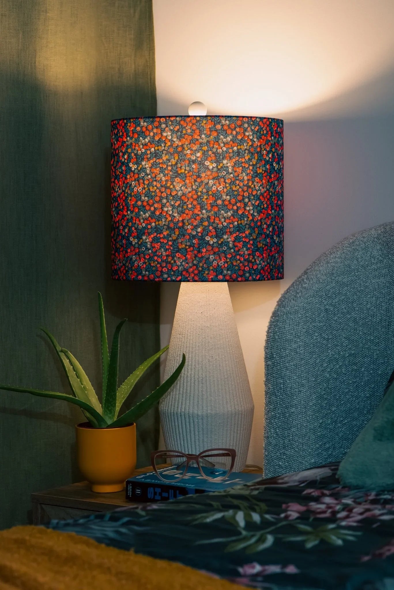 Wildberry drum lampshade in Liberty Wiltshire cotton, glowing on a bedside table in a cozy cottagecore bedroom